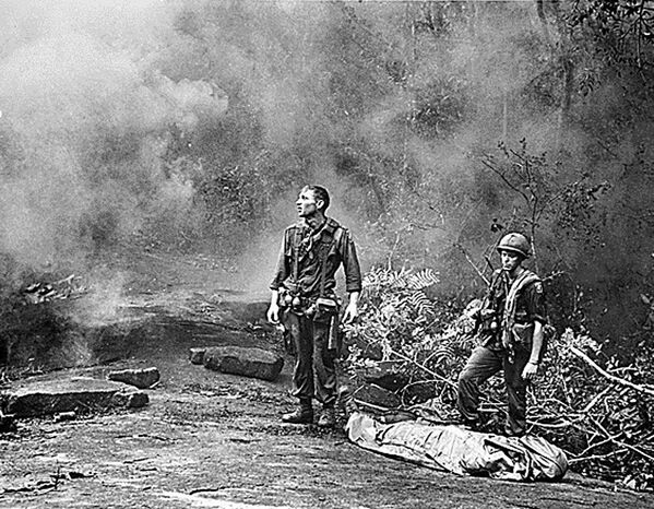 Американские военнослужащие стоят над своим павшим товарищем в ожидании вертолета, который эвакуирует их из джунглей недалеко от провинции Лонг-Кхань, 1966 год. - Sputnik Беларусь