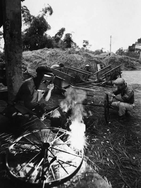Рабочие ремонтируют колеса для рисовых тележек в сельской местности в апреле 1968 года в Северном Вьетнаме. Мастерские по изготовлению оборудования для сельскохозяйственного производства были разрушены американскими бомбардировками. - Sputnik Беларусь