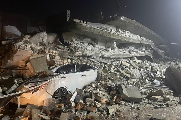 Автомобиль под обломками рухнувшего здания в городе Азмарин, провинция Идлиб, северная Сирия. - Sputnik Беларусь