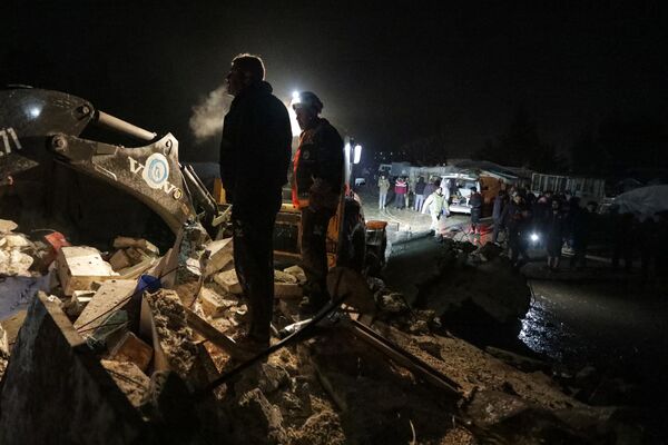 Сирийские спасатели (&quot;Белые каски&quot;) и местные жители на месте обрушившегося здания в пограничном городе Азаз в Алеппо.  - Sputnik Беларусь