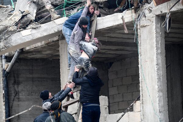 Жители извлекают раненую девочку из-под обломков разрушенного здания после землетрясения в городе Джандарис, в сельской местности города Африн на северо-западе Сирии. - Sputnik Беларусь