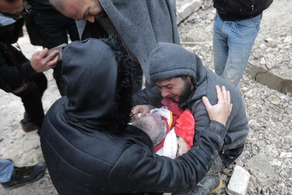 Сириец плачет, неся тело своего сына, погибшего в результате землетрясения в городе Джандарис, в сельской местности города Африн на северо-западе Сирии. - Sputnik Беларусь