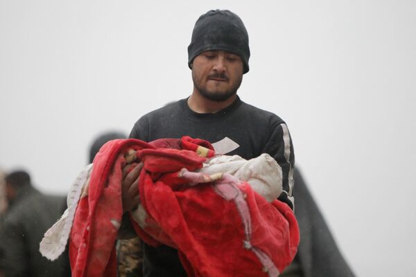 Сириец несет тело младенца, погибшего в результате землетрясения в городе Джандарис, в сельской местности города Африн в сирийской провинции Алеппо. - Sputnik Беларусь