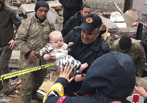Ребенка спасают из разрушенного здания в Малатье, Турция. - Sputnik Беларусь