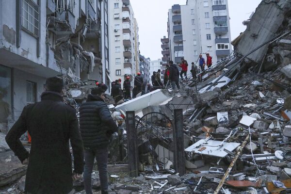 Спасательные команды пытаются добраться до жителей, оказавшихся в ловушке внутри разрушенных зданий в Адане, Турция. - Sputnik Беларусь