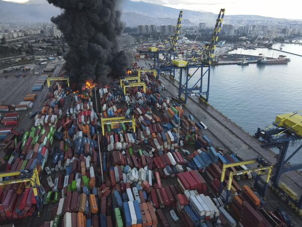 Дым поднимается от горящих контейнеров в порту пострадавшего от землетрясения города Искендерун на юге Турции. - Sputnik Беларусь