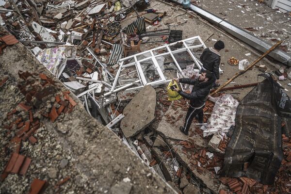 Люди и аварийно-спасательные службы ищут людей в завалах разрушенного здания в Газиантепе, Турция. - Sputnik Беларусь