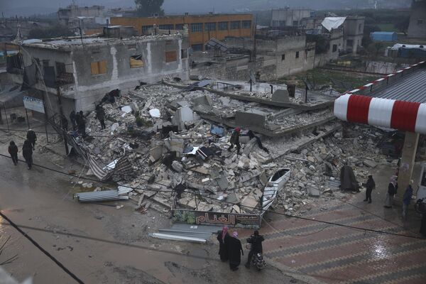 Люди обыскивают разрушенное здание после землетрясения в городе Азмарин, провинция Идлиб. - Sputnik Беларусь
