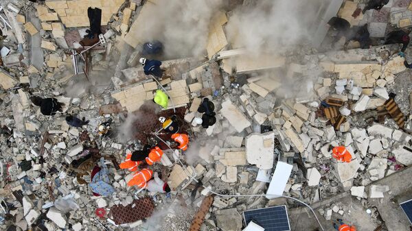 Поиски жертв и выживших под обломками рухнувших зданий после землетрясения в городе Сармада в сирийской провинции Идлиб  - Sputnik Беларусь