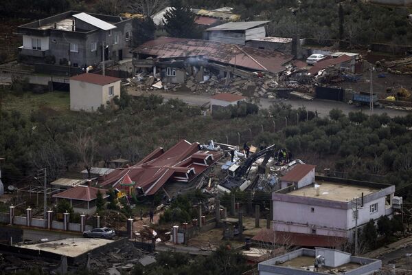 Аварийные бригады ищут людей под обломками разрушенных зданий в городе Нурдаги, на окраине города Османие на юге Турции. - Sputnik Беларусь