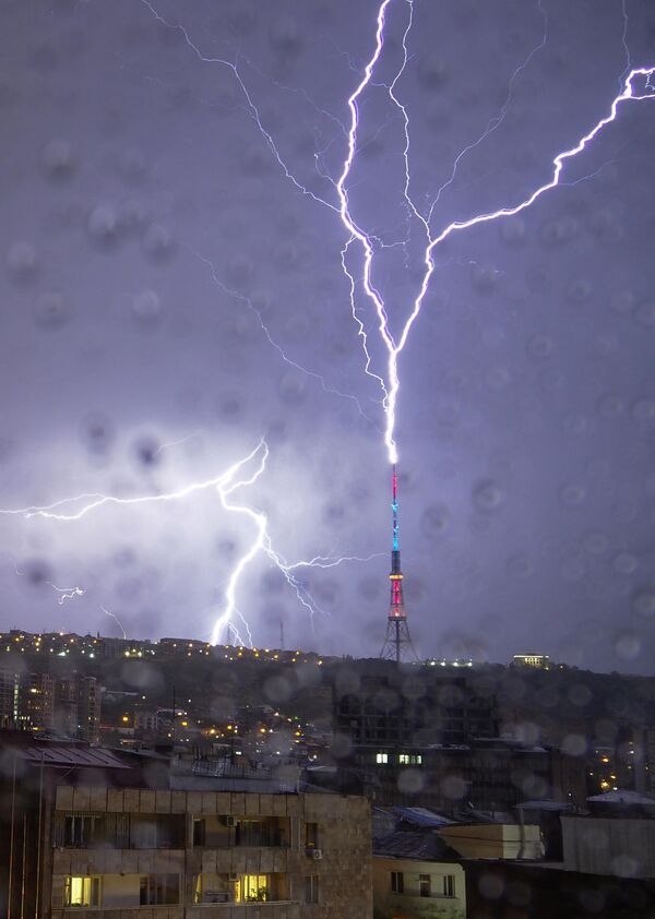 Фото сделано через окно, залитое каплями дождя. Молния попала в телебашню в Ереване, Армения, 4 октября 2020 года. - Sputnik Беларусь