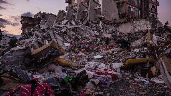 Красные воздушные шары, висящие на обломках рухнувших зданий как символ последних игрушек детей, погибших во время землетрясения в турецком городе Антакья - Sputnik Беларусь