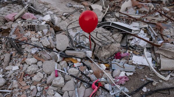 Красные воздушные шары, висящие на обломках рухнувших зданий как символ последних игрушек детей, погибших во время землетрясения в турецком городе Антакья - Sputnik Беларусь