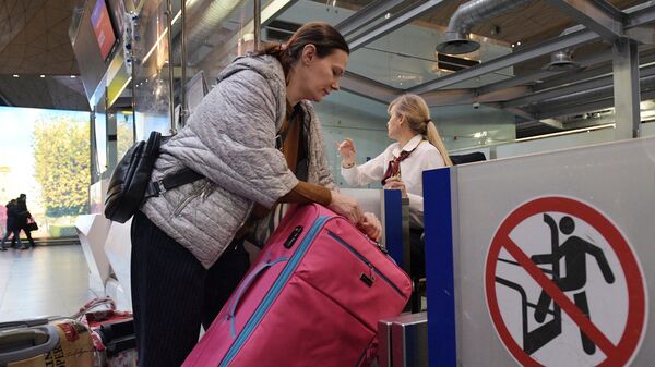 Пассажир оформляет багаж во время регистрации на рейс - Sputnik Беларусь
