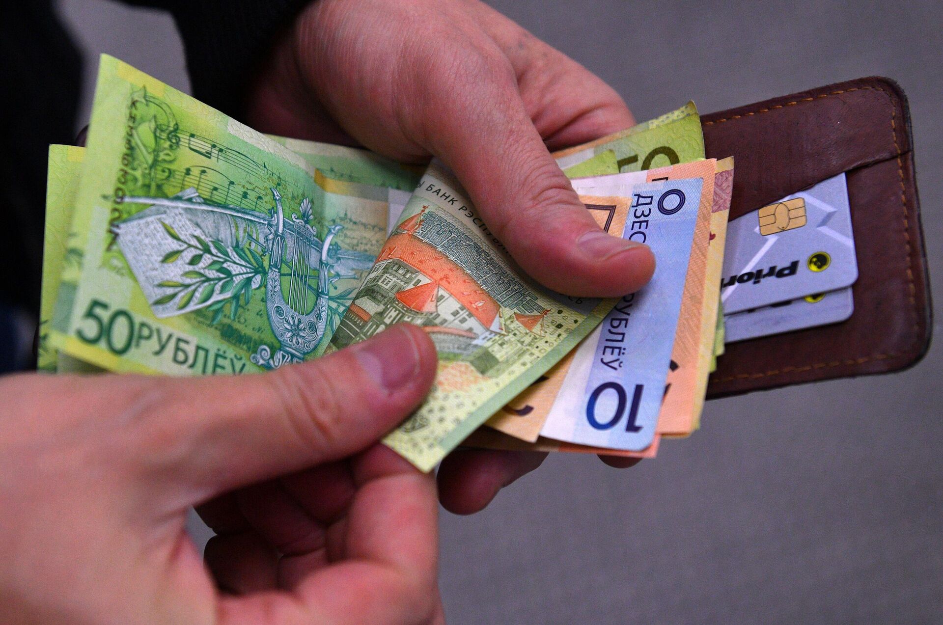 Мужчина считает деньги Мужчина считает деньги - Sputnik Беларусь, 1920, 08.09.2025