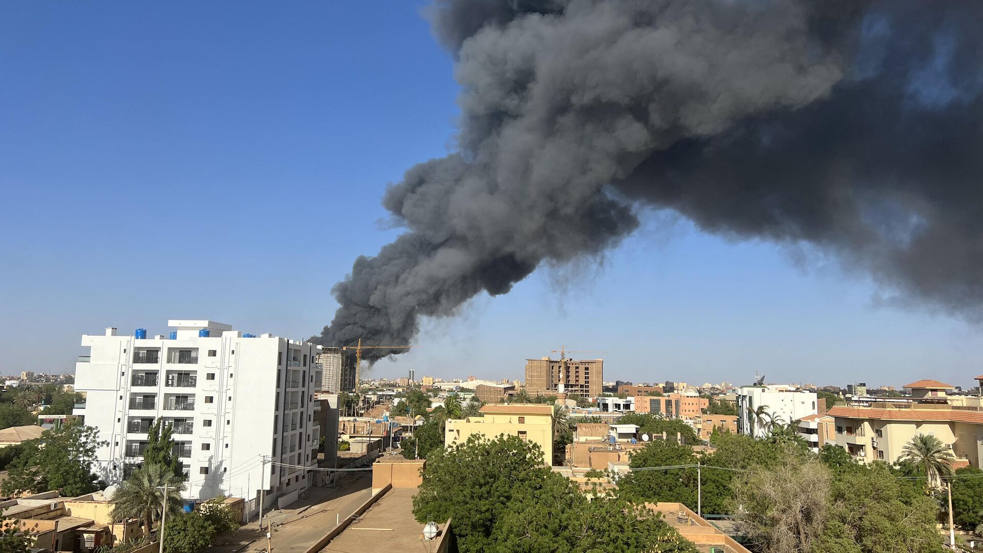Столб дыма над зданиями возле аэропорта в Хартуме, Судан 19 апреля 2023 года - Sputnik Беларусь, 1920, 02.05.2023
