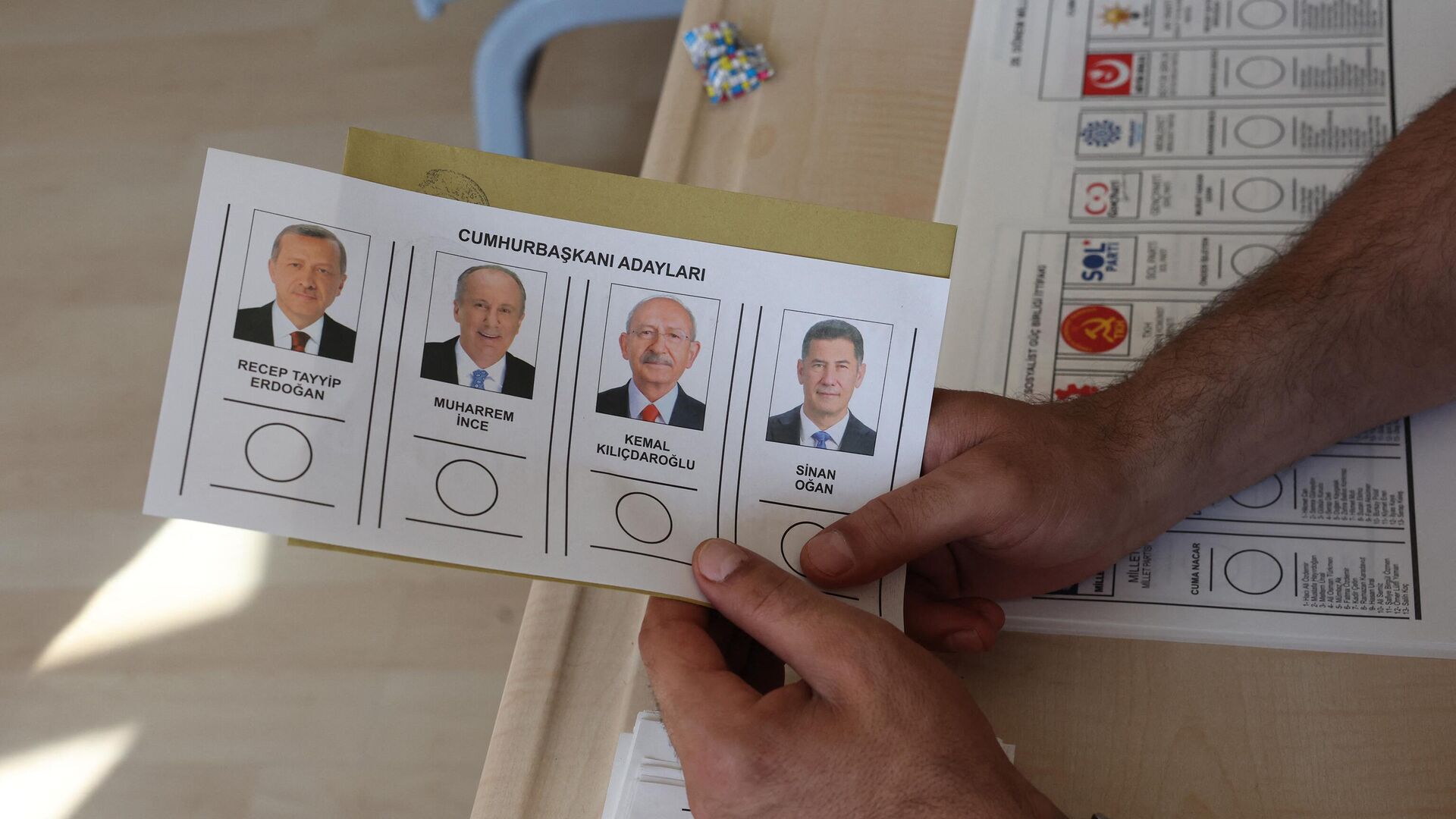Мужчина держит бюллетень на избирательном участке в Анкаре 14 мая 2023 года на парламентских и президентских выборах в Турции - Sputnik Беларусь, 1920, 14.05.2023