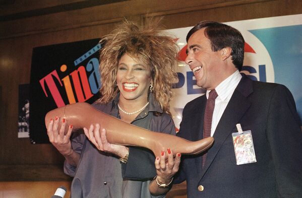 Стройные ножки были яркой частью сценического образа Тернер. В начале 2000-х она их даже застраховала – в случае повреждения нижних конечностей певице было гарантировано получение 3,2 млн долларов США. Тогда это была рекордная сумма. Страховкой певица так и не воспользовалась, а вот оплачивать ее обслуживание пришлось.На фото: Тина Тернер получает шоколадную ногу от президента Pepsi Роджера Энрико в 1985 году.  - Sputnik Беларусь