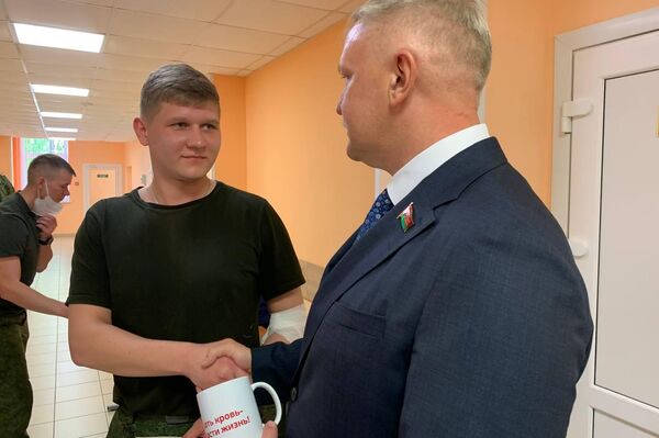 Депутат вручает памятный подарок офицеру Ивану, который впервые сдает кровь - Sputnik Беларусь