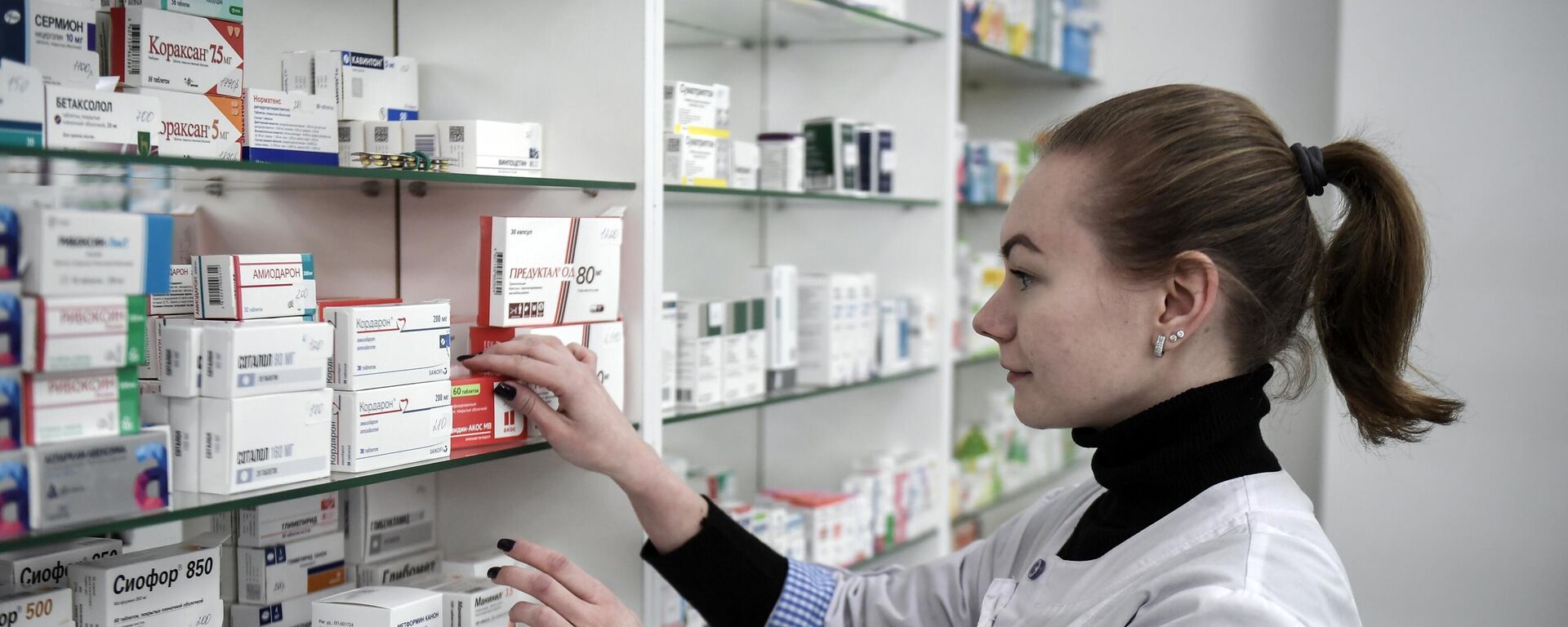 Фармацевт раскладывает лекарства в аптеке - Sputnik Беларусь, 1920, 01.01.2025