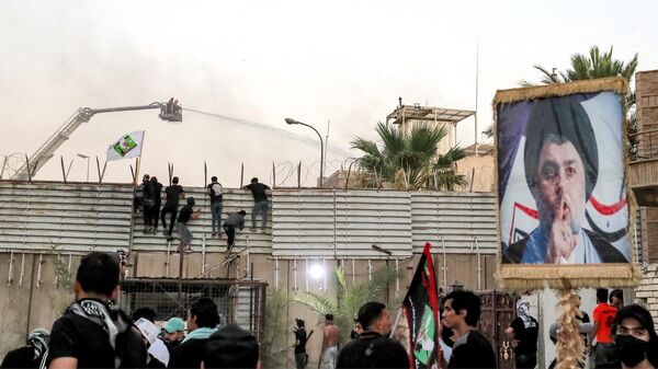 Сторонники иракского шиитского священнослужителя Муктады аль-Садра во время акции протеста перелезают через забор у посольства Швеции в Багдаде - Sputnik Беларусь