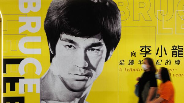 Посетители проходят мимо плаката выставки Брюса Ли в Гонконгском музее, Китай - Sputnik Беларусь