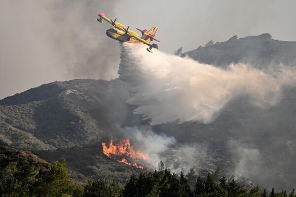 Пожарный самолет сбрасывает воду на лесной пожар в южной части греческого острова Родос. - Sputnik Беларусь