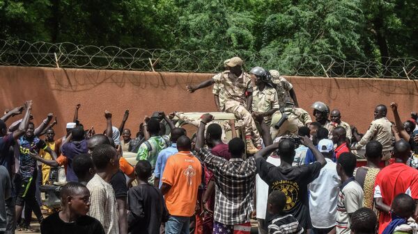 Протестующие приветствуют нигерийские войска, собравшиеся перед посольством Франции в Ниамее во время демонстрации, последовавшей за митингом в поддержку нигерийской хунты - Sputnik Беларусь