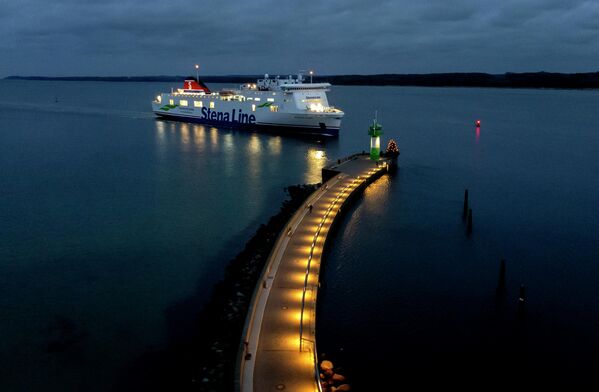 Паром проходит мимо пирса с маяком на подходе к гавани в Травемюнде на Балтийском море, Германия - Sputnik Беларусь