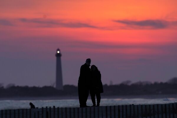 Посетители Кейп-Мей, штат Нью-Джерси, наблюдают закат за маяком - Sputnik Беларусь