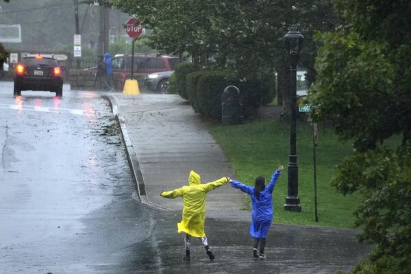 Люди танцуют под дождем во время тропического шторма Ли, суббота, 16 сентября 2023 года, в Бар-Харборе, штат Мэн. - Sputnik Беларусь