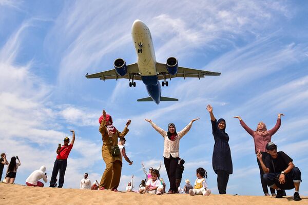 Туристы позируют на пляже Май Као, когда самолет приземляется в международном аэропорту Пхукета в Тайланде.  - Sputnik Беларусь