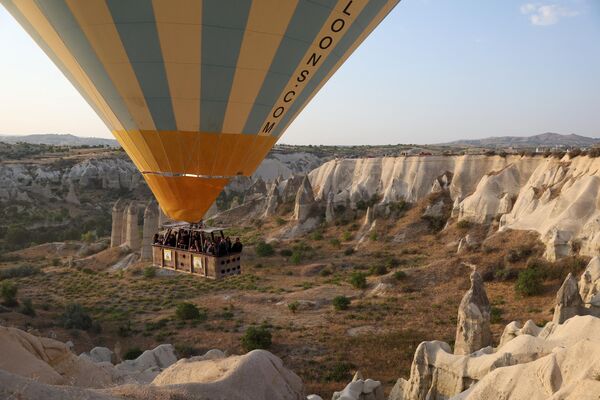 Туристы на воздушном шаре взлетают над национальным парком Гёреме в историческом регионе Каппадокия в центральной Турции. - Sputnik Беларусь