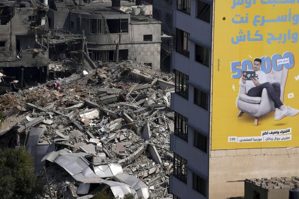 Позднее член политбюро движения ХАМАС Муса Абу-Марзук заявил, что более 100 граждан Израиля, включая высокопоставленных военных, были взяты в плен и удерживаются в секторе Газа.На фото: развалины высотного здания, разрушенного в результате израильских авиаударов в городе Газа. - Sputnik Беларусь