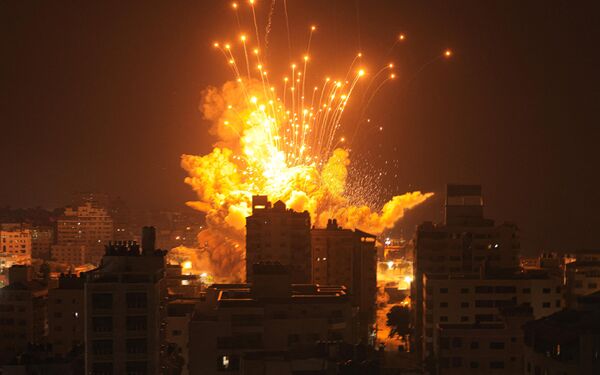 Как сообщило издание &quot;Гаарец&quot;, Израиль уже нанес более 800 ударов по целям в Газе, включая авиаудары, в результате которых была разрушена большая часть города Бейт-Ханун.На фото: ракета взрывается в городе Газа во время израильского воздушного удара. - Sputnik Беларусь