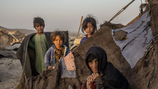 Женщина и дети среди разрушений после землетрясения в районе Зинда Джан в провинции Герат на западе Афганистана - Sputnik Беларусь