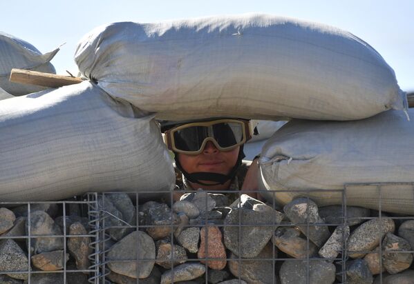 Кыргызский военнослужащий смотрит в бойницу каменного габиона. - Sputnik Беларусь