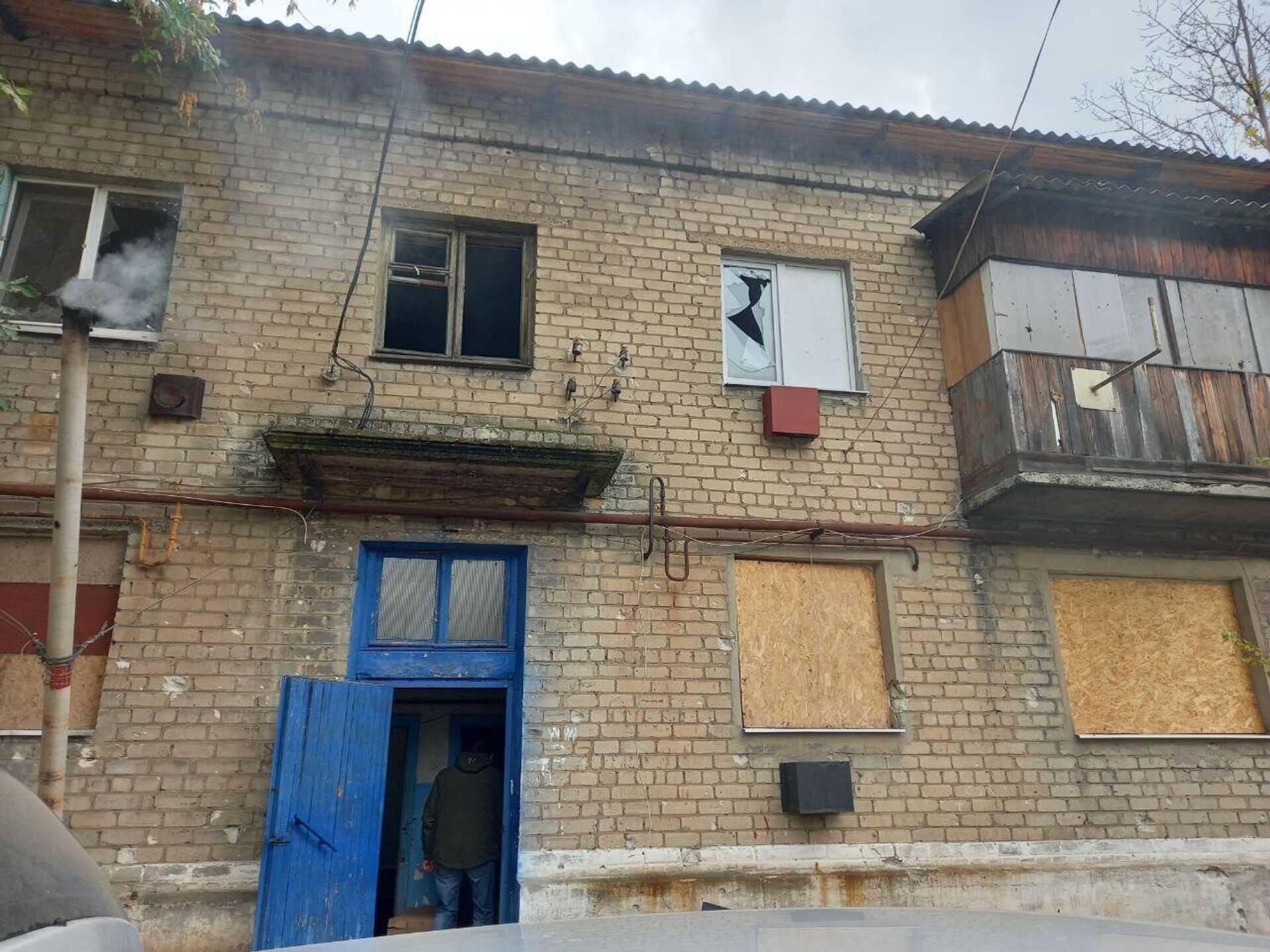 Один из домов в поселке Сапртак: выбитые окна заделаны листами фанеры, за отопление отвечает печка-буржуйка, ее труба видна слева - Sputnik Беларусь, 1920, 13.10.2023