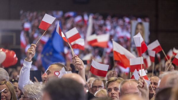 Сторонники главной оппозиционной партии Гражданская коалиция (Koalicja Obywatelska) машут польскими флагами на митинге 13 октября 2023 года, в последний день агитации. - Sputnik Беларусь