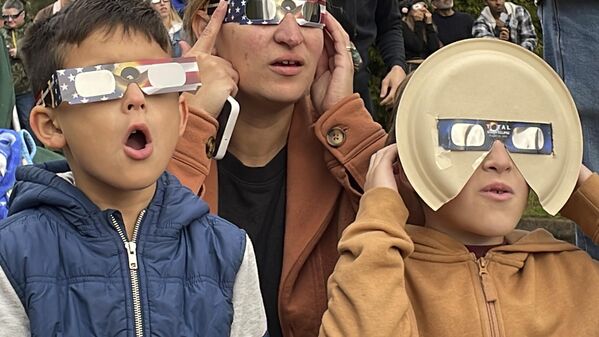 Самия Харбо, ее сын Логан и сын ее друга в очках, которые они сделали еще к затмению 2017 года. - Sputnik Беларусь