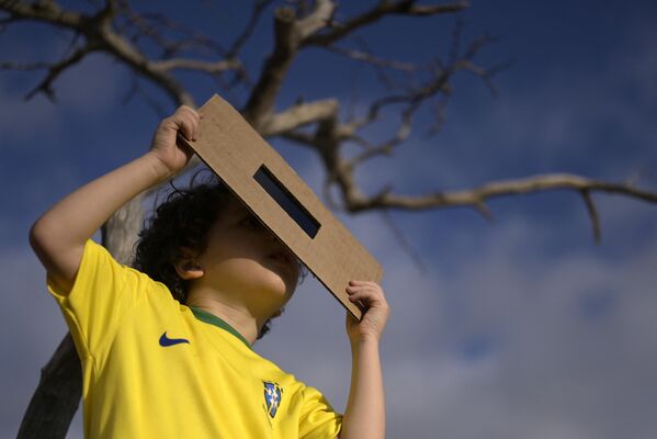 Мальчик наблюдает за кольцеобразным солнечным затмением на стадионе Минейран в Белу-Оризонти, штат Минас-Жерайс, Бразилия. - Sputnik Беларусь