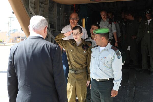 Гилад Шалит приветствует премьер-министра Израиля Биньямина Нетаньяху после приземления на авиабазе ЦАХАЛ в центре Израиля 18 октября 2011 года. Израильский военнослужащий провел в плену более 5 лет и был освобожден в обмен на 1027 палестинских заключенных. - Sputnik Беларусь
