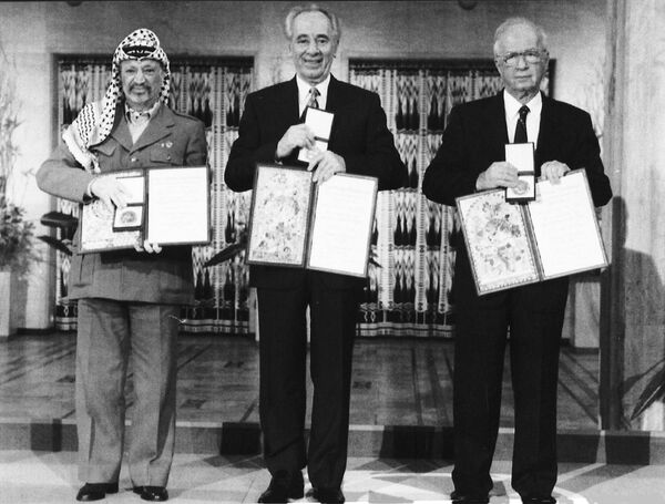 На этой фотографии, сделанной 10 декабря 1994 года, лидер ООП Ясир Арафат (слева), премьер-министр Израиля Ицхак Рабин (в центре) и министр иностранных дел Израиля Шимон Перес позируют после получения Нобелевской премии мира 1994 года в городе Осло. Они получили премию &quot;за усилия по установлению мира на Ближнем Востоке&quot;. Награда была призвана придать импульс мирным усилиям на Ближнем Востоке. Процесс провалился, и в следующем году Ицхак Рабин был убит израильтянином-ультранационалистом, который выступал против мирной инициативы. - Sputnik Беларусь