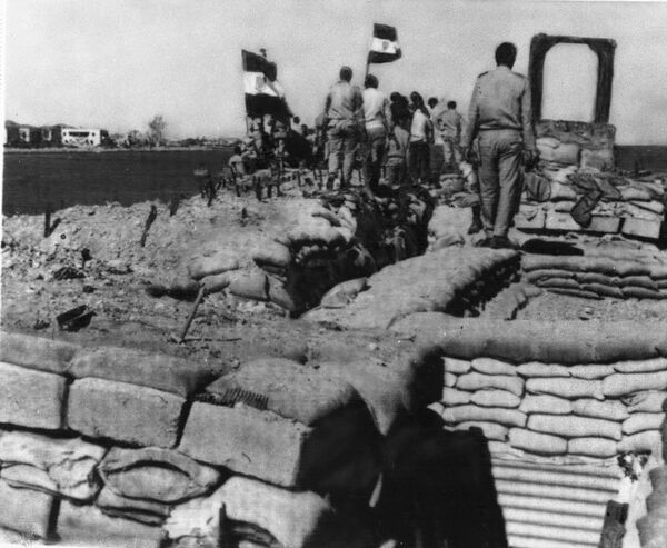 Египетские войска во время войны Судного дня нанесли серьезный урон израильской армии, оккупировавшей Синайский полуостров после шестидневной войны. На фото: египетские солдаты установили флаг на линии укреплений Бар-Лева в Синайской пустыне в октябре 1973 года. Мощное фортификационное сооружение никак не помогло израильской армии, но стоило стране огромных сил и средств. - Sputnik Беларусь