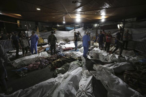 Тела палестинцев, погибших в результате взрыва в больнице  Аль-Ахли, собраны во дворе больницы Аль-Шифа в городе Газа. - Sputnik Беларусь