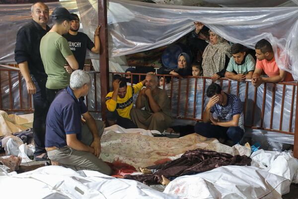Родственники оплакивают тела палестинцев, погибших в результате удара по больнице Ахли Араб. - Sputnik Беларусь