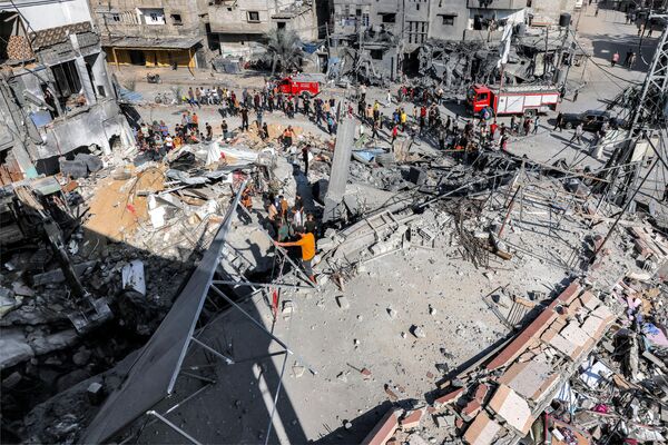 Число жертв в секторе Газа превысило 8,5 тысячи человек, свыше 21 тысячи получили ранения.На фото: сотрудники гражданской обороны ищут погибших и выживших среди обломков здания, пострадавшего от израильской бомбардировки, в Рафахе на юге сектора Газа 31 октября 2023 года. - Sputnik Беларусь