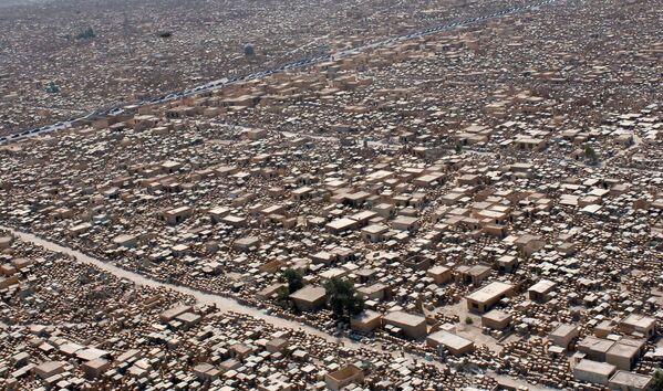 Кладбище Вади ас-Салам – переводится как &quot;Долина мира&quot; – в Ан-Наджафе занимает площадь 601,16 гектаров, здесь более 5 миллионов захоронений. Погребения совершаются ежедневно уже на протяжении 1400 лет. На кладбище похоронено много известных мусульман, в частности, в центре его находится могила Али ибн Абу Талиба, четвертого халифа; недалеко от нее захоронены великий аятолла Мухаммад Бакир ас-Садр и его сестра Амина ас-Садр. Некоторые шииты считают, что двенадцатый имам появляется возле мечети Вади ас-Салам каждый четверг во время намаза на закате.На фото: сотни автомобилей выстроились вдоль шоссе во время паломничества к храму Имама Али, который разделяет кладбище &quot;Долина мира&quot; в Ан-Наджафе. - Sputnik Беларусь