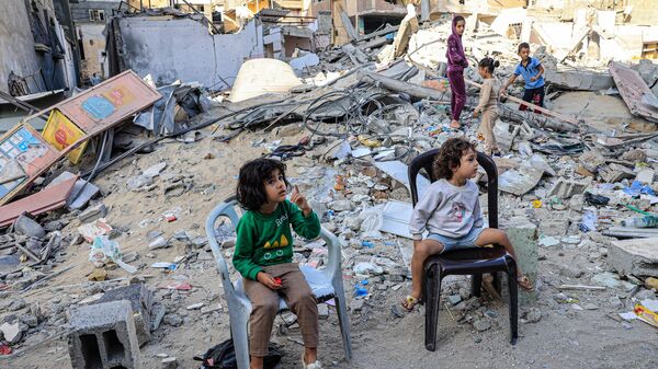 Палестинские дети перед обломками разрушенного здания в Рафахе на юге сектора Газа - Sputnik Беларусь