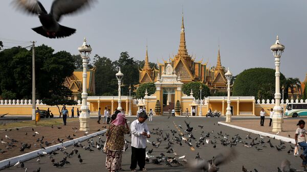 Люди кормят голубей возле Королевского дворца в Пномпене, Камбоджа - Sputnik Беларусь